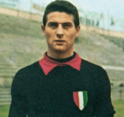 Morte di Lorenzo Buffon: L'ultimo volo del Signore che parava senza paura 1 Un raro primo piano vintage a colori di Lorenzo Buffon da giovane con la maglia nera del Milan dal colletto rosso e lo scudetto tricolore sul petto, un'immagine simbolo condivisa dopo la notizia della morte di Lorenzo Buffon.