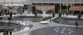 Vista di Piazza Gae Aulenti a Milano, luogo dove una donna di 43 anni è stata accoltellata alle spalle. L’immagine mostra l’area moderna con fontane e passanti.