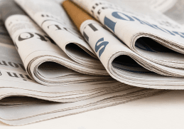 Rassegna stampa oggi 07/11/2025: pile di quotidiani italiani piegati su un tavolo di legno, simbolo delle notizie del giorno.