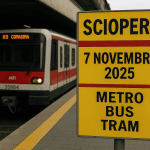 Sciopero 7 novembre 2025 a Milano: orari e info su metro, bus e tram ATM 21 Cartello giallo con la scritta “Sciopero 7 novembre 2025 metro bus tram” alla stazione di Milano, con treno e tram ATM fermi sullo sfondo.